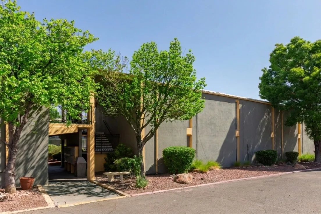 Tree-shaded entrance to Uptown Horizon Apartments on Lomas Blvd NE